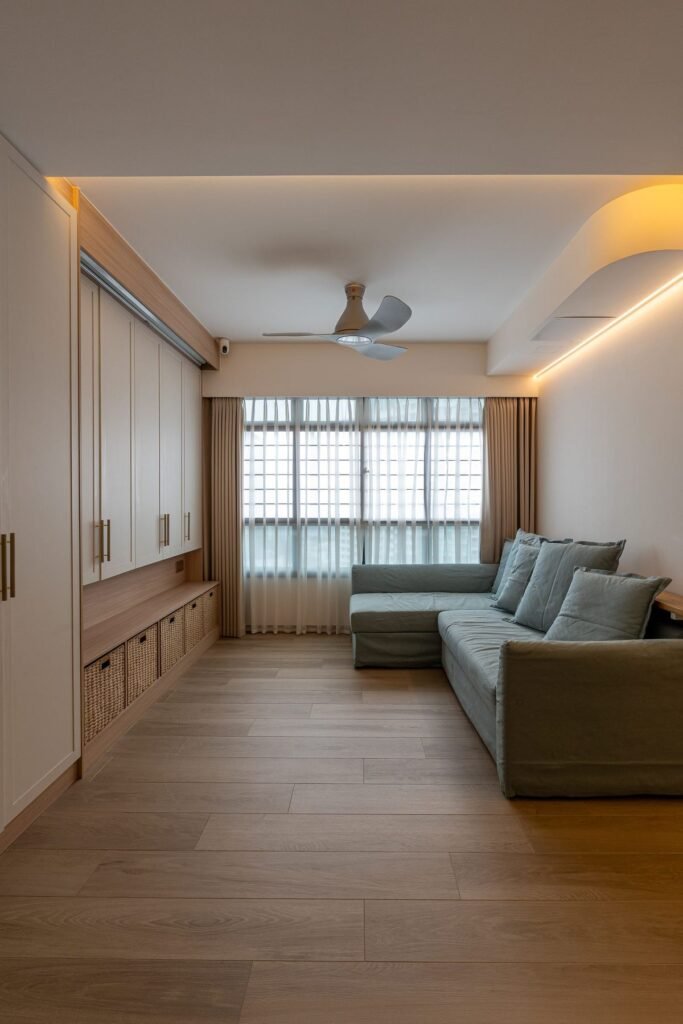 Living room with full-height storage and a grey sofa by the window