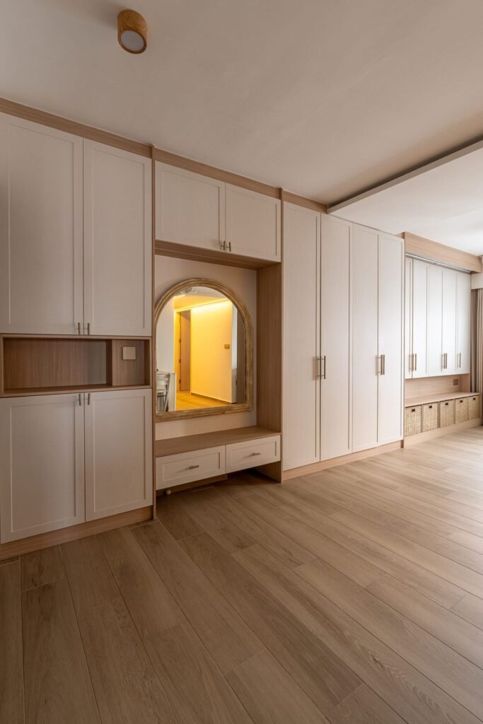 Wall of white wardrobes with an arched vanity niche