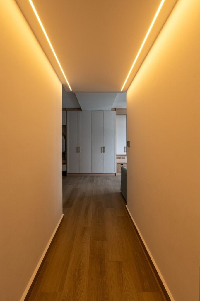 Corridor with cove lighting and light oak flooring