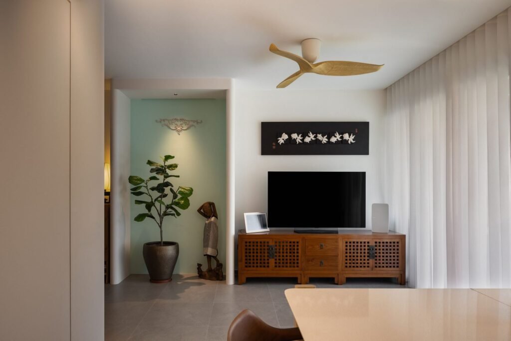 Living room with a carved timber TV console and jade-green niche