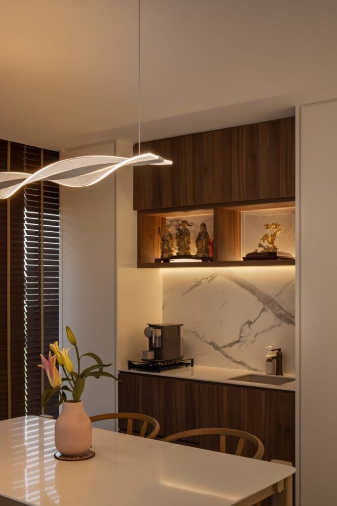 Dining area with a lit walnut display shelf and marble-look backsplash