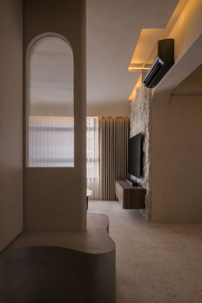 Arched fluted-glass screen between the entrance and living room